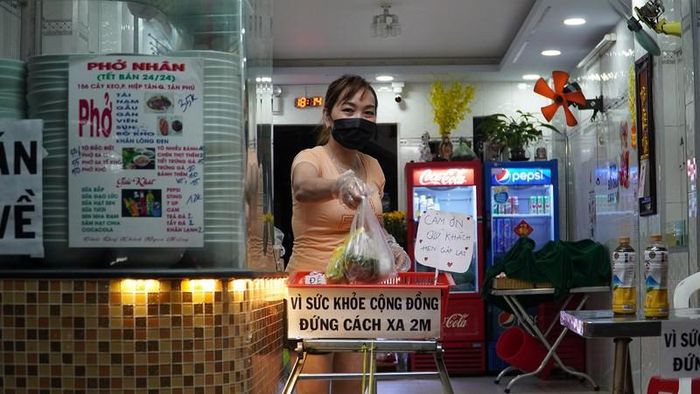 Vợ ông Nhân giao phở cho khách bằng ròng rọc. Ảnh: NGUYỄN TIẾN
