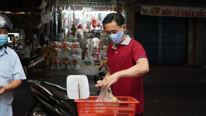 Khách hàng nhận tiền thừa và phở trong chiếc rổ để sẵn. Ảnh: NGUYỄN TIẾN