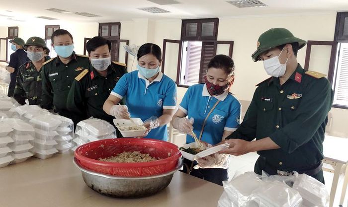 Chị Tuyết (thứ 3, từ phải qua) cùng lo bữa cơm chiều cho công dân cách ly. 