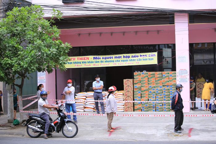 Mọi người đến lấy phải giữ trật tự và đeo khẩu trang, tuân thủ xếp hàng cách nhau 2 mét được kẻ sẵn trên nền đất để đảm bảo an toàn