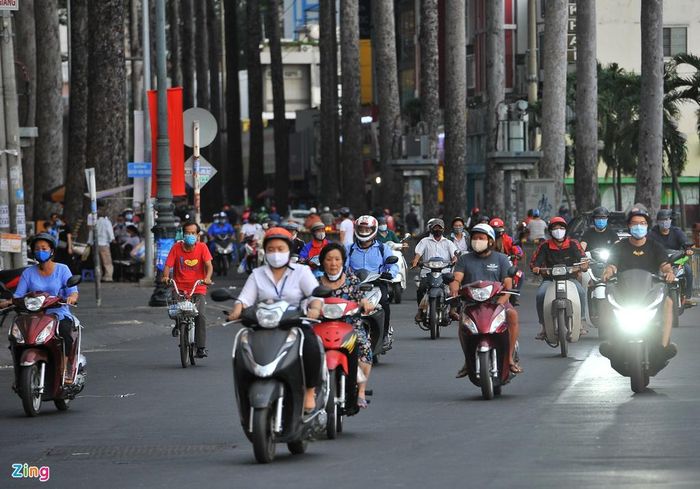 Thời điểm này trên đường Nguyễn Thị Minh Khai trời khá tối, 15h40 chiều mà một số người đi xe máy phải bật đèn sáng để quan sát.