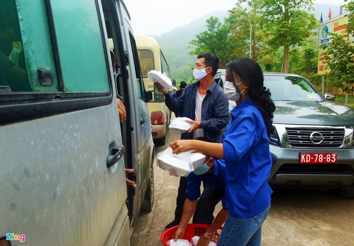  Trước khi lên xe, họ được tình nguyện viên cấp phát đồ ăn, thức uống dọc đường. 