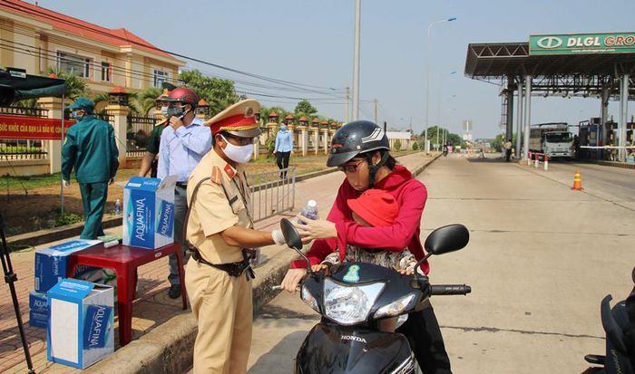 Lực lượng Công an phát nước uống cho người tham gia giao thông.