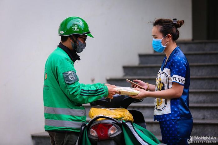 Trong thời gian cách ly toàn xã hội, những người hoạt động nhiều nhất có lẽ là nhân viên giao hàng (shipper). Công việc khá vất vả, bận rộn nhưng có thu nhập. Tuy vậy, hàng ngày tiếp xúc với nhiều người, khó tránh khỏi nguy cơ lây nhiễm Covid-19 nên thực hiện đeo khẩu trang, rửa tay sát khuẩn thường xuyên là yêu cầu bắt buộc... Ảnh: Đức Anh