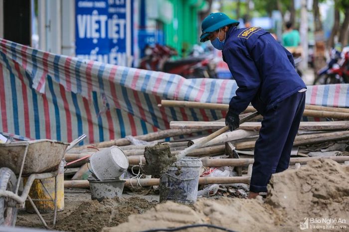 Trong thời gian cách ly toàn xã hội, công việc xây dựng vẫn được phép hoạt động. Dịp này, có khá nhiều người lao động từ các huyện về thành phố Vinh làm thợ hồ. Thực hiện quy định về đeo khẩu trang và giãn cách tối thiểu 2m nên có phần bất tiện khi làm việc. Ảnh: Đức Anh