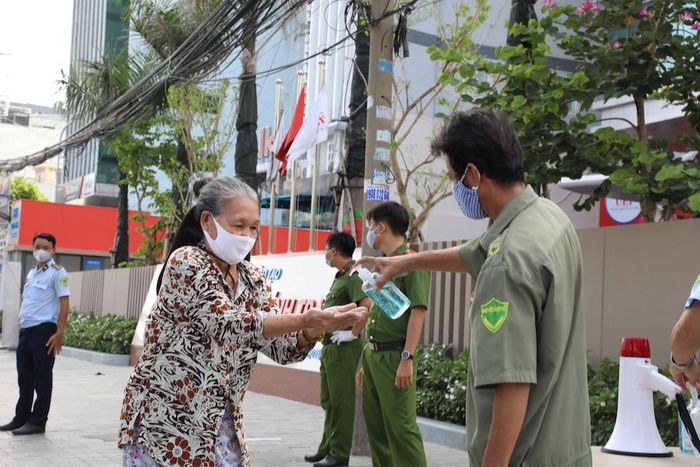 Khi tới nhận gạo họ sẽ được nhân viên sát khuẩn