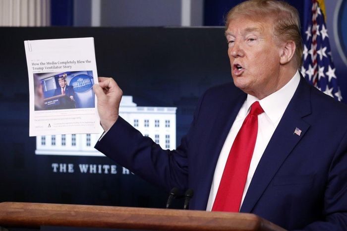 Tổng thống Donald Trump cầm một bài báo trong cuộc họp báo về virus corona hôm 20/4 tại Nhà Trắng. Ảnh: AP.