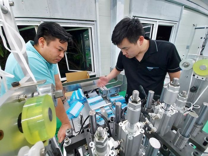 Nhóm thợ sửa máy sản xuất khẩu trang, trong đó có anh Lý Liên Kiệt chuyển nghề từ thợ nhôm kính. Ảnh: M.Đ