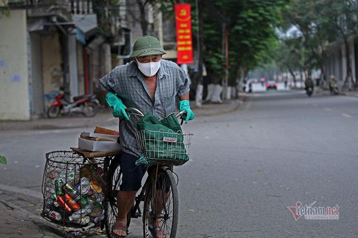 Ông Nam đi nhận phần thực phẩm bằng chiếc xe đạp vẫn thường dùng làm nghề ve chai của mình.