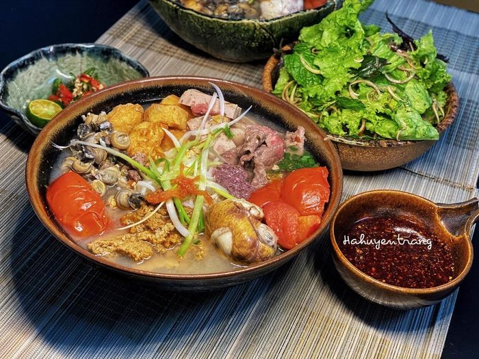 Bún riêu ốc là món ăn quen thuộc với người Hà Nội. Món ăn nhiều màu này có những nguyên liệu gồm ốc, đậu, cua, thịt bò, cà chua, gia vị. Ăn kèm bún riêu ốc không thể thiếu các loại rau thơm và ớt chưng. Nếu tự làm tại nhà, bạn có thể thay thịt bò thành nguyên liệu khác như chả giò tùy ý thích.