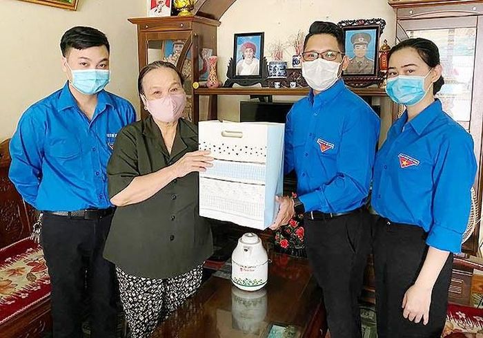Anh Nguyễn Xuân Hùng (thứ hai từ phải sang) cùng đoàn viên, thanh niên Bát Xát trao các phần quà và nhu yếu phẩm hỗ trợ gia đình người có công với cách mạng trên địa bàn huyện.