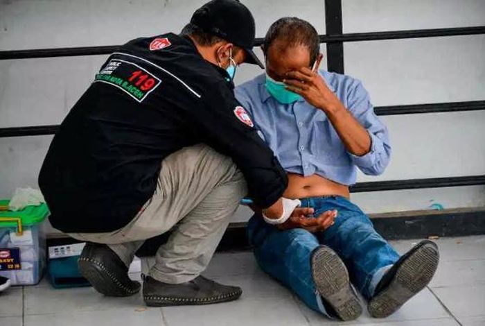 Nhân viên y tế đang kiểm tra cho người đàn ông bị đánh.