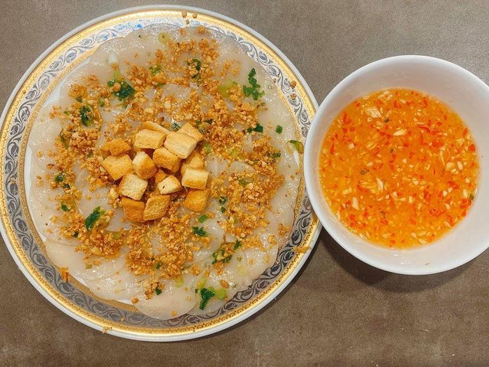 Sau đó, bạn rưới lạc đã rang và bánh mì chiên giòn lên đĩa bánh đã bày trước đó, chan nước mắm và thưởng thức.