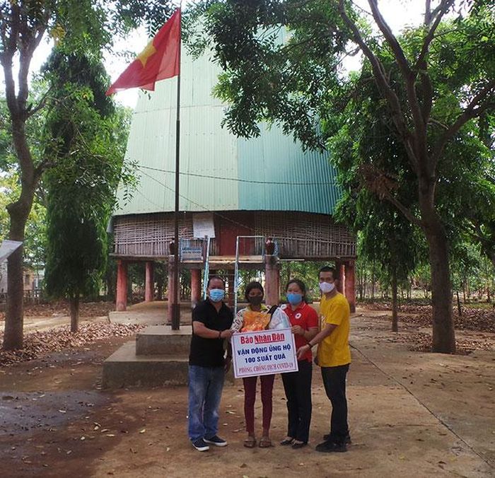 Phóng viên thường trú Báo Nhân Dân cùng nhà tài trợ trao quà tại nhà rông Rơ Wăk, thôn Plei Rơ Wăk, xã Đăk Năng, TP Kon Tum.