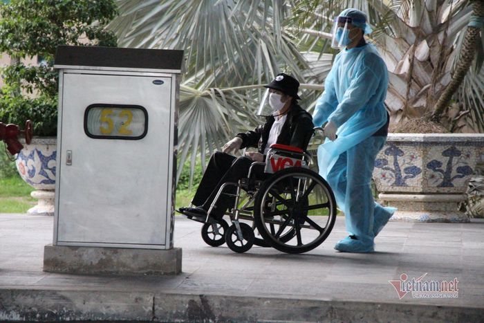 Người bệnh, người già và phụ nữ mang thai được hỗ trợ đưa ra xe bằng xe lăn 