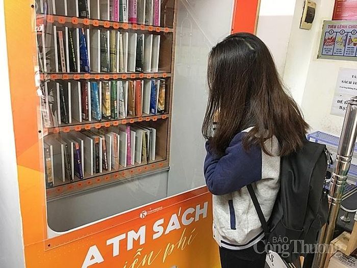 Người đến nhận sách thao tác trực tiếp tại cây ATM sách bằng nút bấm...