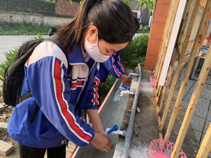 Học sinh rửa tay trước khi vào trường.