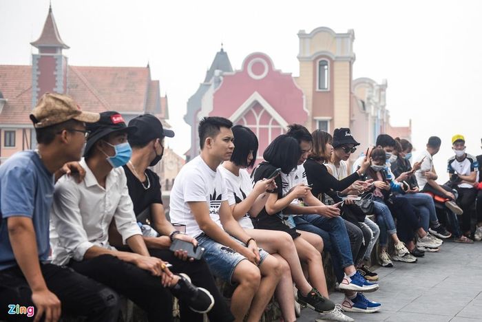 Bạn trẻ ngồi sát nhau, vô tư trò chuyện, không đeo khẩu trang hay thực hiện giãn cách xã hội.