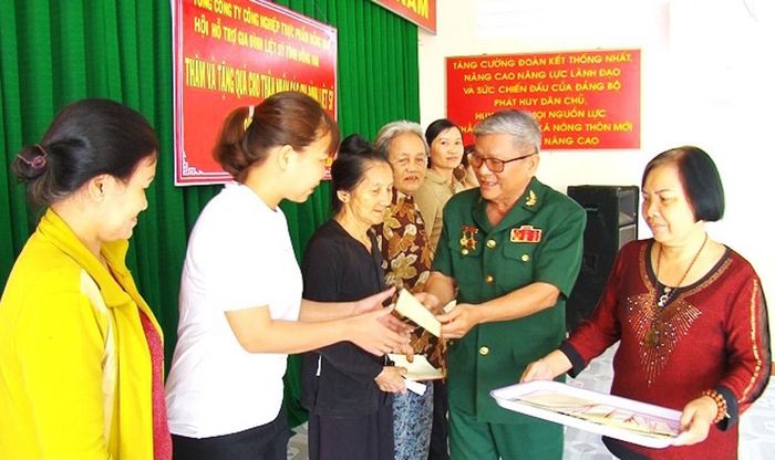Đại diện Lữ đoàn Thông tin 23 (Quân khu 7) trao quyết định tặng nhà tình nghĩa tới gia đình chính sách ở huyện Xuân Lộc. Ảnh: LÊ HOAN.