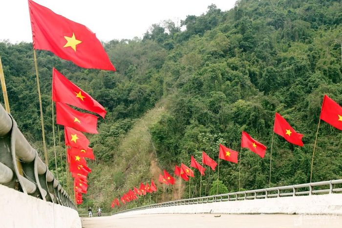 Tại các bản làng miền Tây Nghệ An dịp này cũng thắm đỏ sắc cờ Tổ quốc, nhân lên không khí rộn ràng và niềm tin về sự phát triển của quê hương, đất nước. Ảnh chụp tại cầu Tam Quang, thuộc xã Tam Quang. Ảnh: Đình Tuân