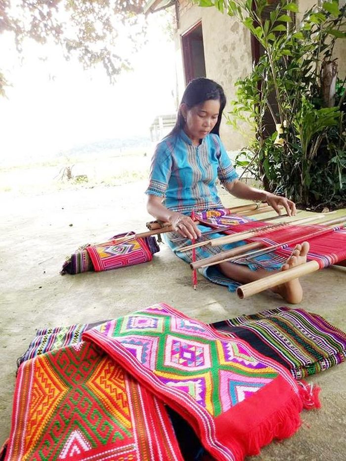 Nghệ nhân Ka Điều đang dệt vải dưới gốc cây trong sân nhà