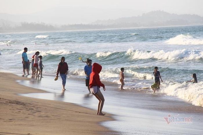 Người lớn, trẻ em nô đùa trên bãi biển