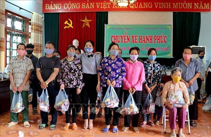 Các hộ gia đình xã Tú Sơn, huyện Kim Bôi nhận quà hỗ trợ. Ảnh: Thanh Hải/TTXVN