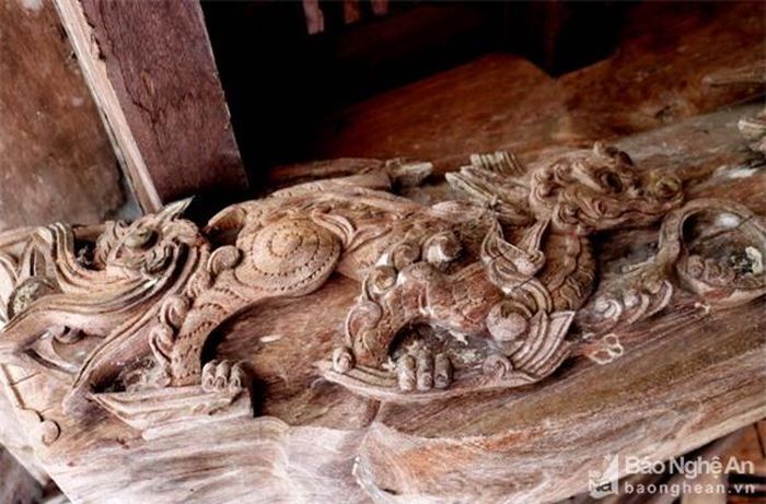 Một con nghê được chạm nổi trên kẻ hiên trước, trông rất sống động và uyển chuyển. Ảnh: Huy Thư