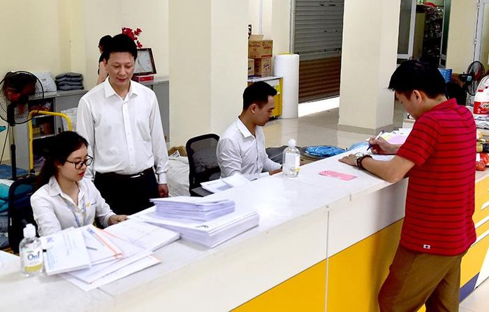 Giám đốc Nguyễn Xuân Hùng kiểm tra công việc tại khu vực giao dịch.