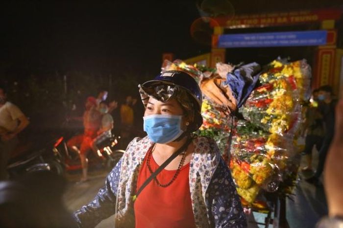 Ngay sau dỡ bỏ lệnh cách ly người dân trong thôn nhanh chóng vận chuyển hoa ra chợ bán. Ảnh: Minh Quyết - TTXVN