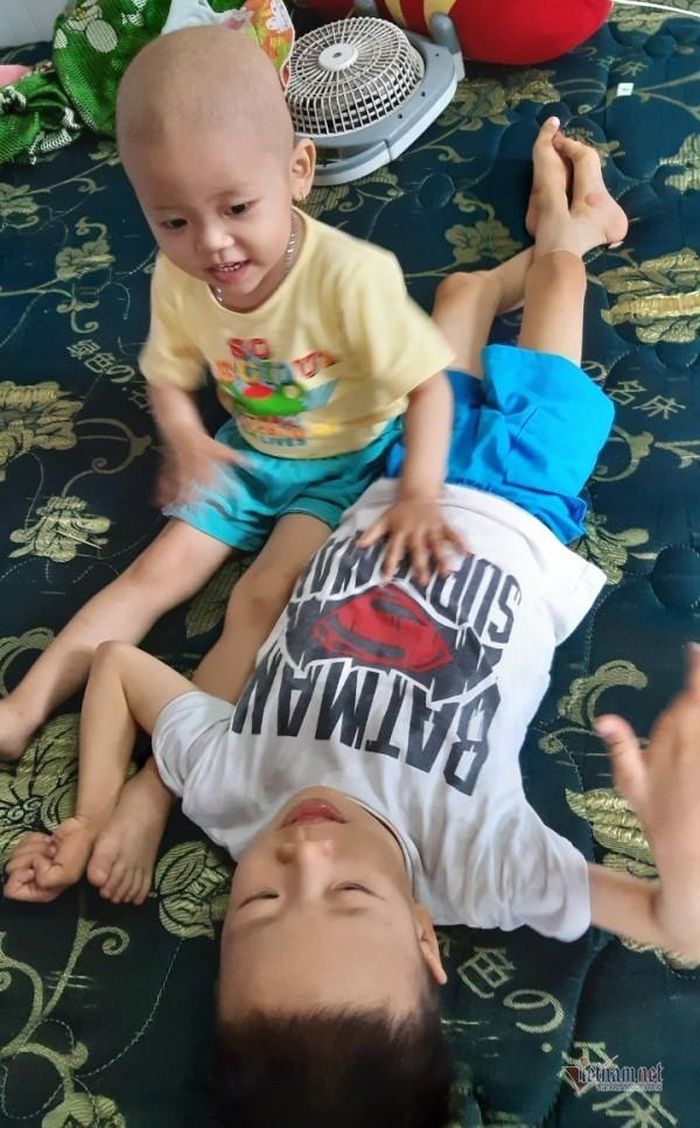 Bé Anh Thi vui vẻ bên anh trai.