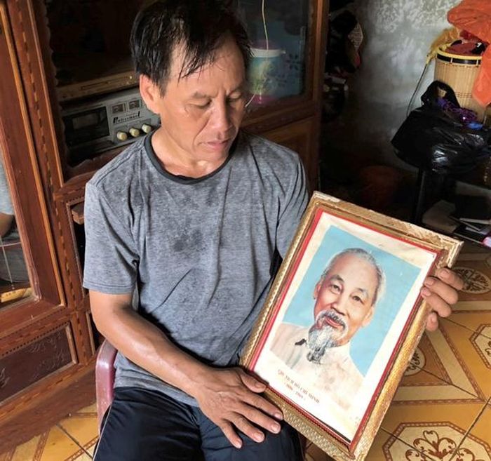 Anh Hin treo ảnh Bác Hồ ở nơi trang trọng nhất trong nhà, lâu lâu lại lấy ảnh Bác xuống lau bụi. Ảnh: Đ.Y