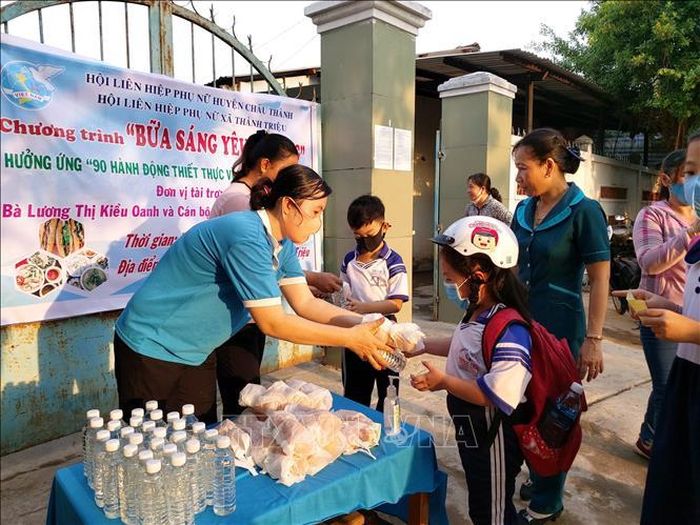 Phụ nữ xã Thành Triệu, huyện Châu Thành, phát bánh mỳ ốp la hỗ trợ "Bữa ăn sáng yêu thương" cho học sinh.
