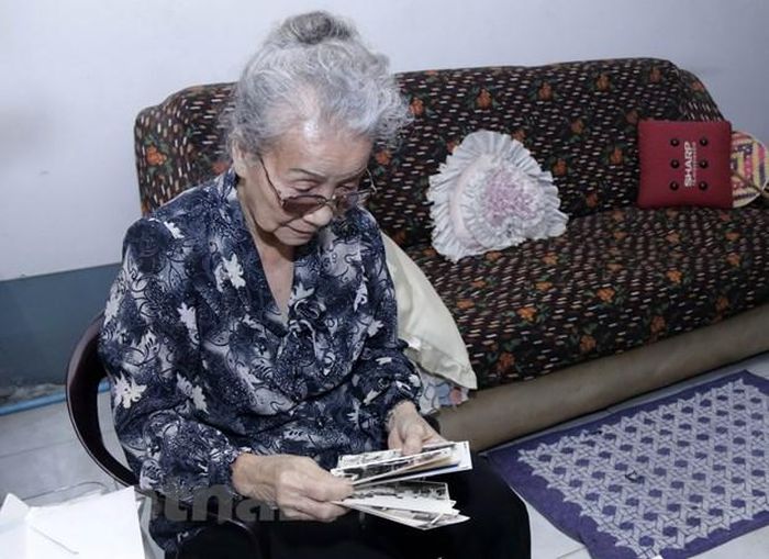 Bà Nguyễn Thị Nương vừa liên tục giải thích về ý nghĩa của từng bức ảnh, bà vừa kể về những ký ức từ lúc nhỏ, khi nghe bố mẹ, bà con chòm xóm kể về Bác, về phong trào lập bàn thờ Bác của bà con Việt kiều Thái Lan khi đó. (Ảnh: Phạm Kiên/Vietnam+)