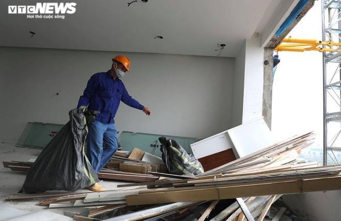 Phía bên trong, các công nhân đang gấp rút dọn dẹp phế liệu để chuẩn bị phá tường.