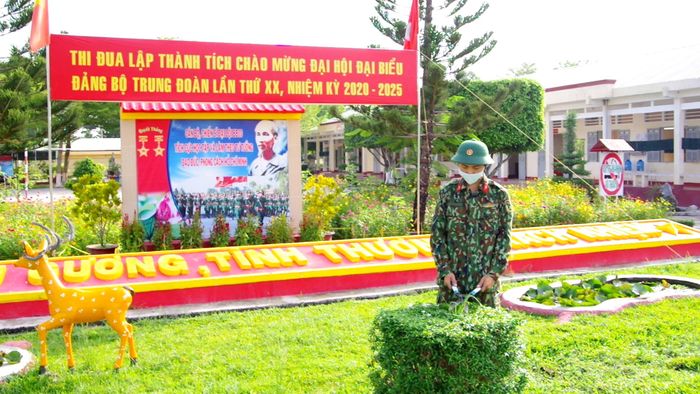 Binh nhì Thái Bá Dũng chăm sóc cảnh quan đơn vị.