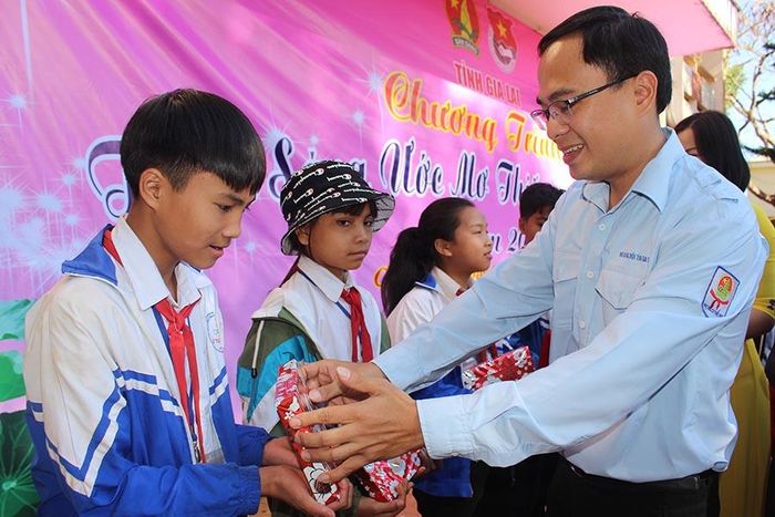 Anh Đỗ Đức Thanh-Phó Chủ tịch Hội đồng Đội tỉnh tặng quà các em học sinh khó khăn tại chương trình “Thắp sáng ước mơ thiếu nhi Gia Lai” tổ chức vào cuối năm 2019. Ảnh: P.L