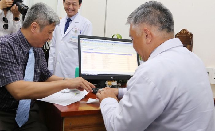 Thứ trưởng Nguyễn Trường Sơn (trái) xem quy trình đăng ký thanh toán trực tuyến (Ảnh: BVCC)