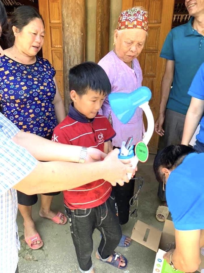 Con trai chị Nguyễn Thị Hoa - Công nhân Đội 4, Công ty Lâm nghiệp Ngòi Sảo rất háo hức với món quà "cực phẩm" là chiếc đèn học chống cận thương hiệu Rạng Đông mà các cô chú công đoàn trao tặng