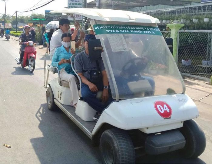Du khách tham quan làng hoa bằng xe điện