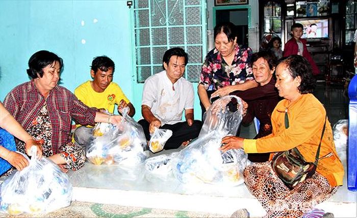 Các thành viên Nhóm khuyết tật Tình bạn, Đoàn kết sắp xếp những phần cơm từ thiện để chuyển đến các thành viên. Ảnh: V.Truyên