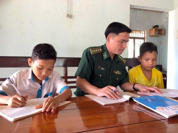 Đại úy Lê Tuấn Anh tranh thủ hướng dẫn 2 cháu là con nuôi của đơn vị học tập. Ảnh: A.H