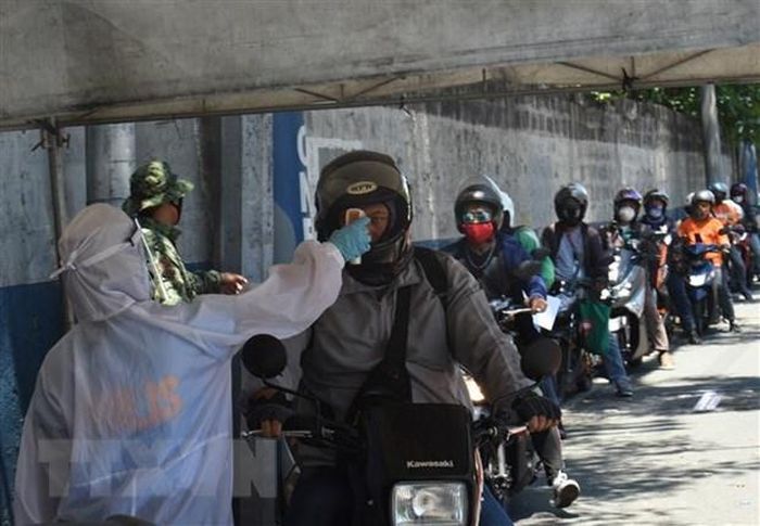 Cảnh sát Philippines kiểm tra thân nhiệt phòng lây nhiễm COVID-19 tại tỉnh Rizal phía đông Manila. (Ảnh: AFP/TTXVN)