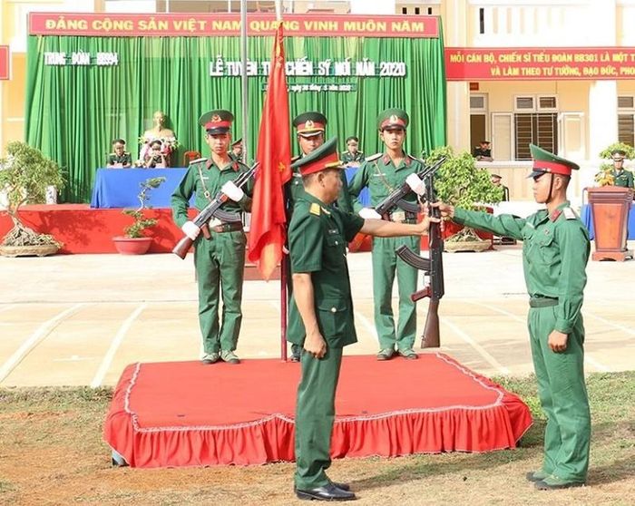 Chỉ huy Trung đoàn 994 thực hiện nghi thức trao súng cho chiến sĩ mới.