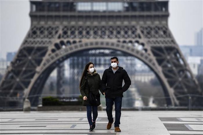 Người dân đeo khẩu trang phòng dịch COVID-19 tại Paris ngày 18/3/2020. Ảnh: AFP/TTXVN