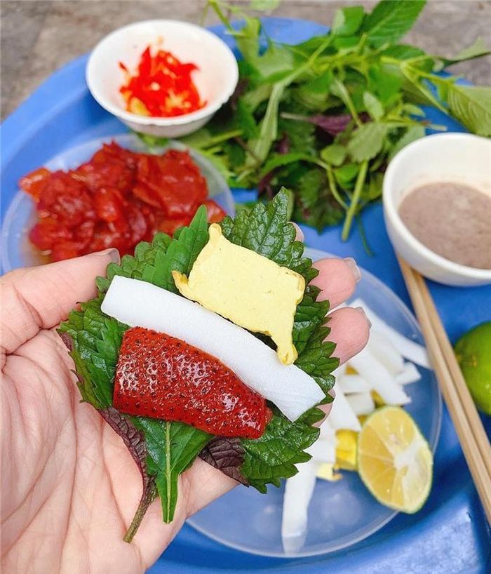 Khi ăn, bạn cần đặt lá tía tô xuống trước, thêm chút rau kinh giới, một miếng đậu và cùi dừa, lát sứa đỏ đã được chấm đủ mắm tôm. Sau đó, bạn chỉ cần nhẹ nhàng cuộn lại và thưởng thức. Ảnh: Trangpinkyy. 