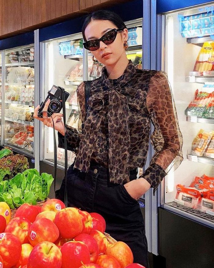 Phí Phương Anh lăng xê xu hướng trang phục họa tiết da báo trên nền vải xuyên thấu. Quán quân The Face Vietnam 2016 chọn loại áo xuyên thấu khoe lưng trần nuột nà, còn phía trước được may lớp vải lót màu đen quyến rũ. Cô kết hợp áo cùng quần jeans, đeo kính mát đen sành điệu. Ảnh: @phi.phuonganh.