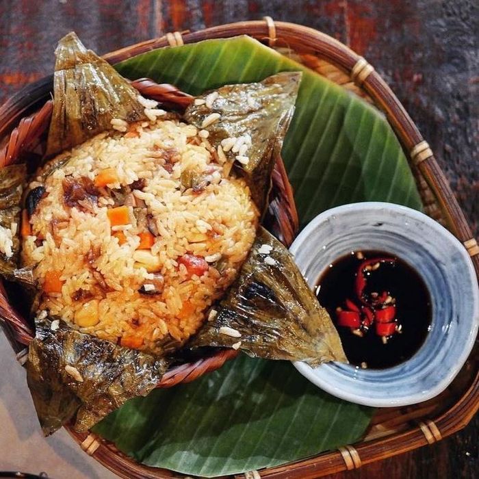 Món cơm sẽ thêm đậm vị khi kết hợp cùng hải sản. Bạn xào phần hải sản cùng các nguyên liệu khác như đậu Hà Lan, cà rốt, hành tây, hành lá, nấm... Sau khi xào chín, bạn cho cơm và hỗn hợp nguyên liệu vào giữa lá sen, thêm phụ gia rồi gói kín và hấp khoảng 10 phút. Khi thưởng thức, bạn hãy nhai thật chậm để cảm nhận hết cái ngon của món ăn này. Ảnh: Rey.winter.stuf, Cassandretpe. 