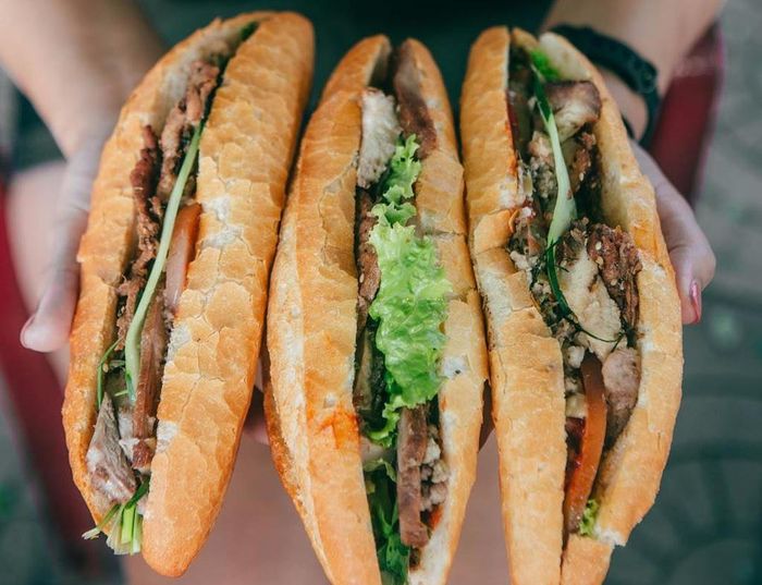  Bánh mì là một trong những món ăn nâng tầm thương hiệu ẩm thực phố cổ khi được giới thiệu trên nhiều tạp chí du lịch thế giới. Do đó, bạn không nên bỏ qua cơ hội thưởng thức món ăn từng khiến người nước ngoài phải xếp hàng dài chờ đợi. Bánh được thêm nhiều loại nhân kèm rau sống và nước sốt đặc biệt. Giá khoảng 30.000 đồng. Ảnh: Foodiswhyimbroke. 