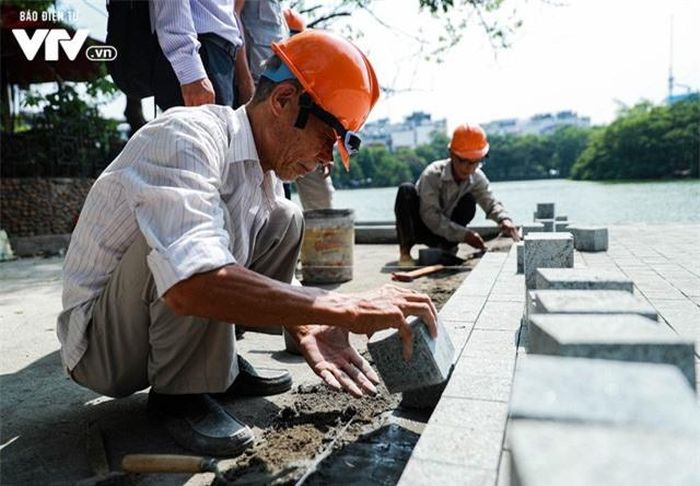 Các công nhân thực hiện công việc ốp lát, từng viên đá sẽ được đặt xen kẽ nhau và được kết dính bằng xi măng